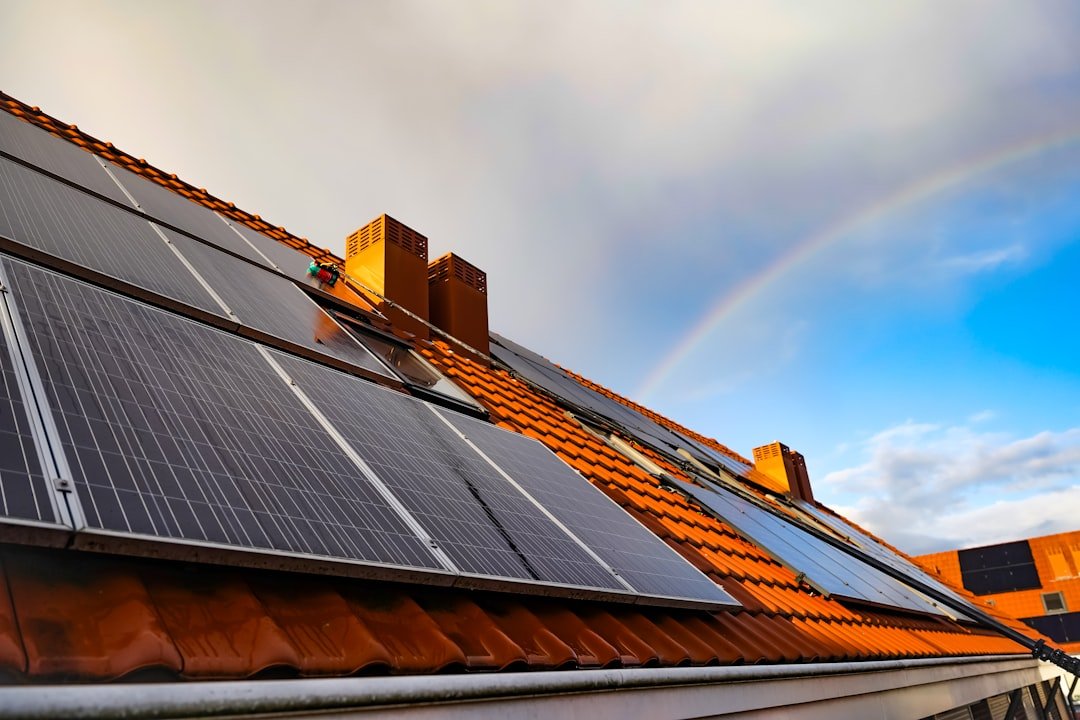a-solar-panel-on-a-roof-with-a-rainbow-in-the-background-0syvpkyzc-m